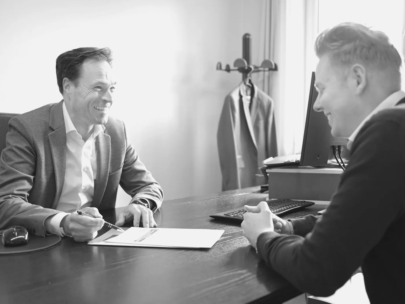 Consultor explica os números do contrato para o cliente na mesa do escritório